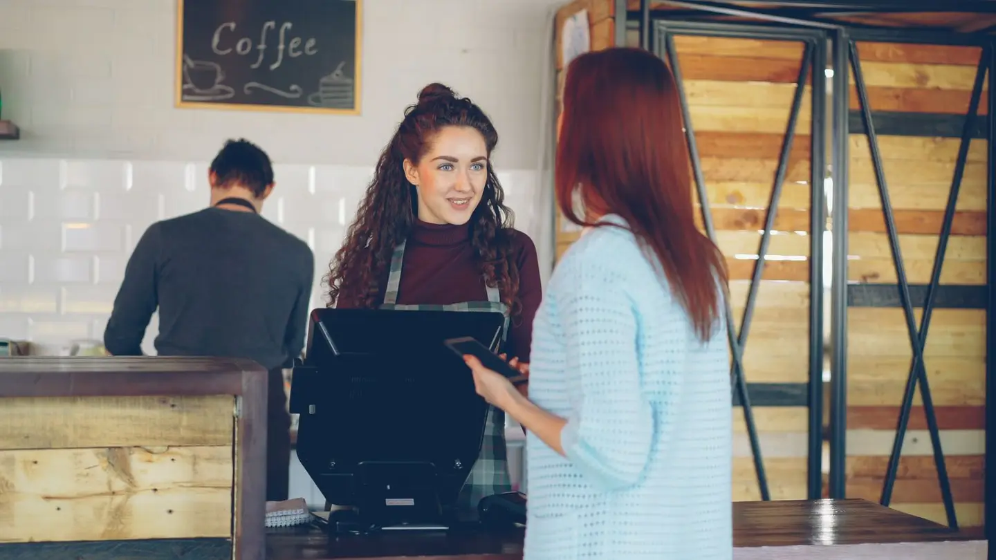 Friendly Barista Serving Customer at a Café