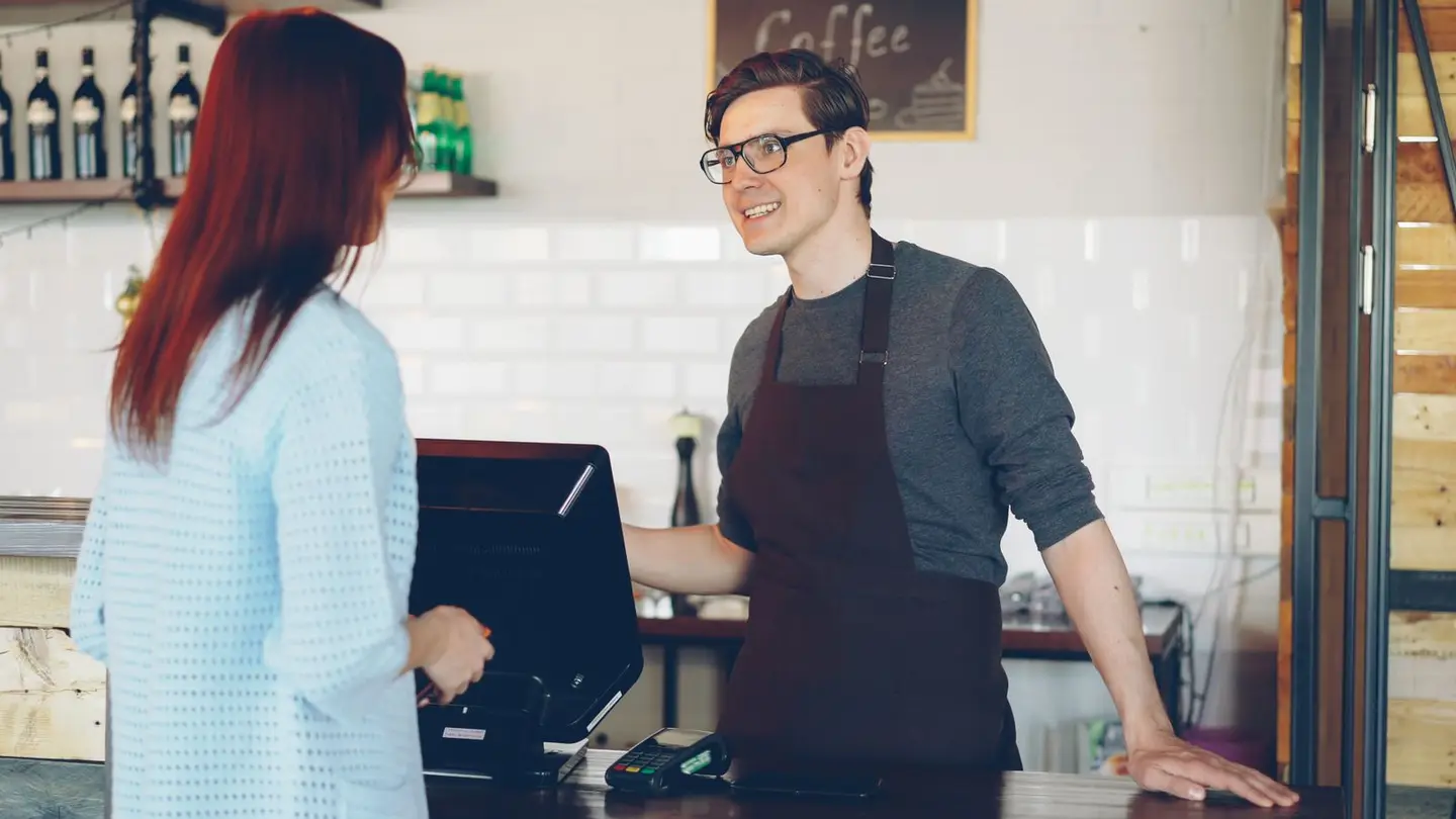 Barista Assisting Customer in Modern Cafe