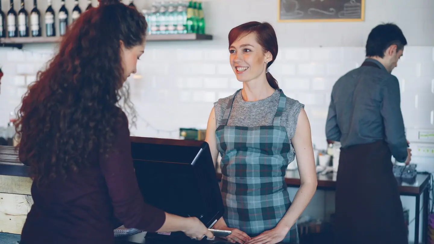 Friendly Barista Serving Customer in Cafe