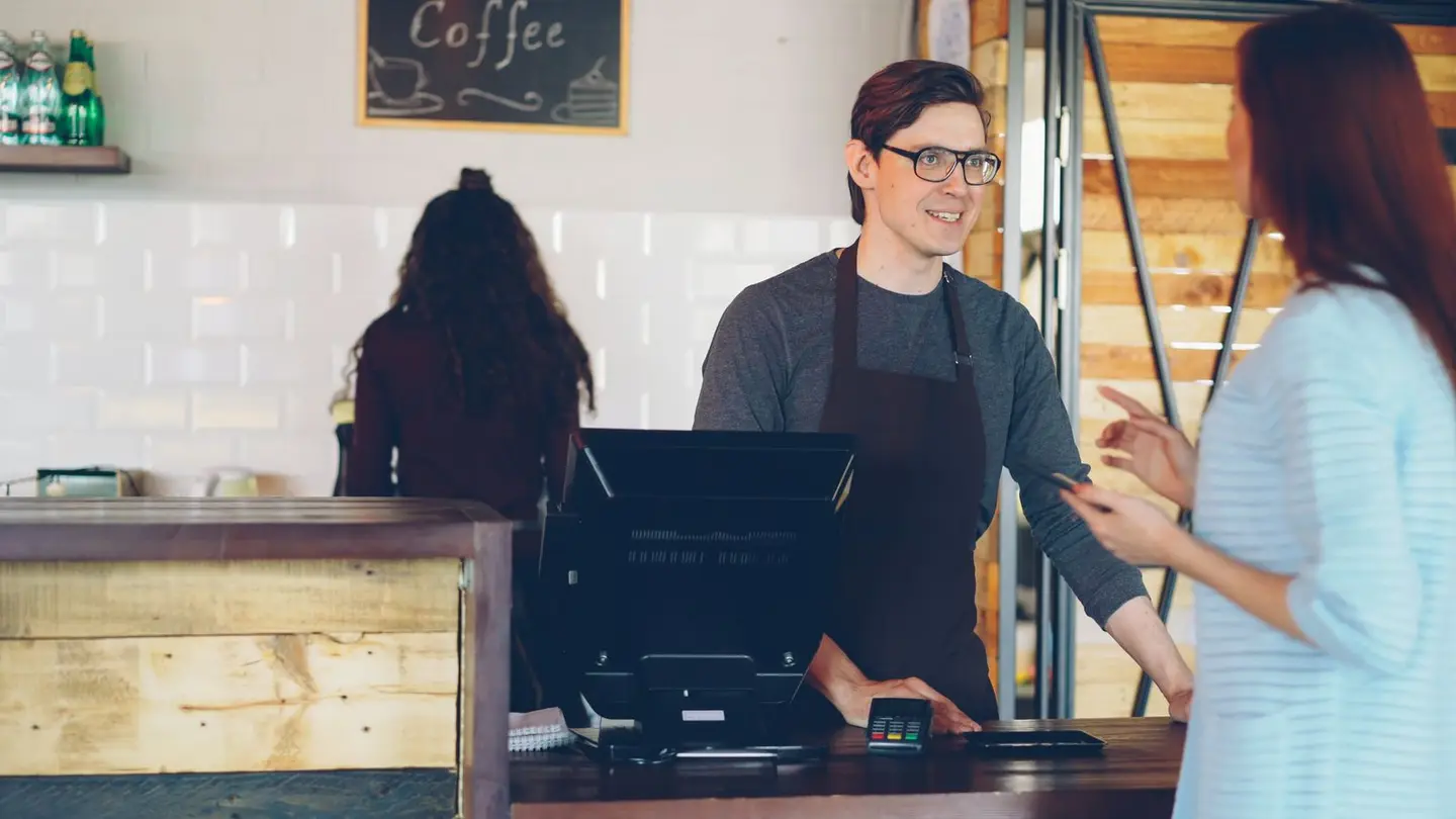 Friendly Barista Serving Customer in Coffee Shop