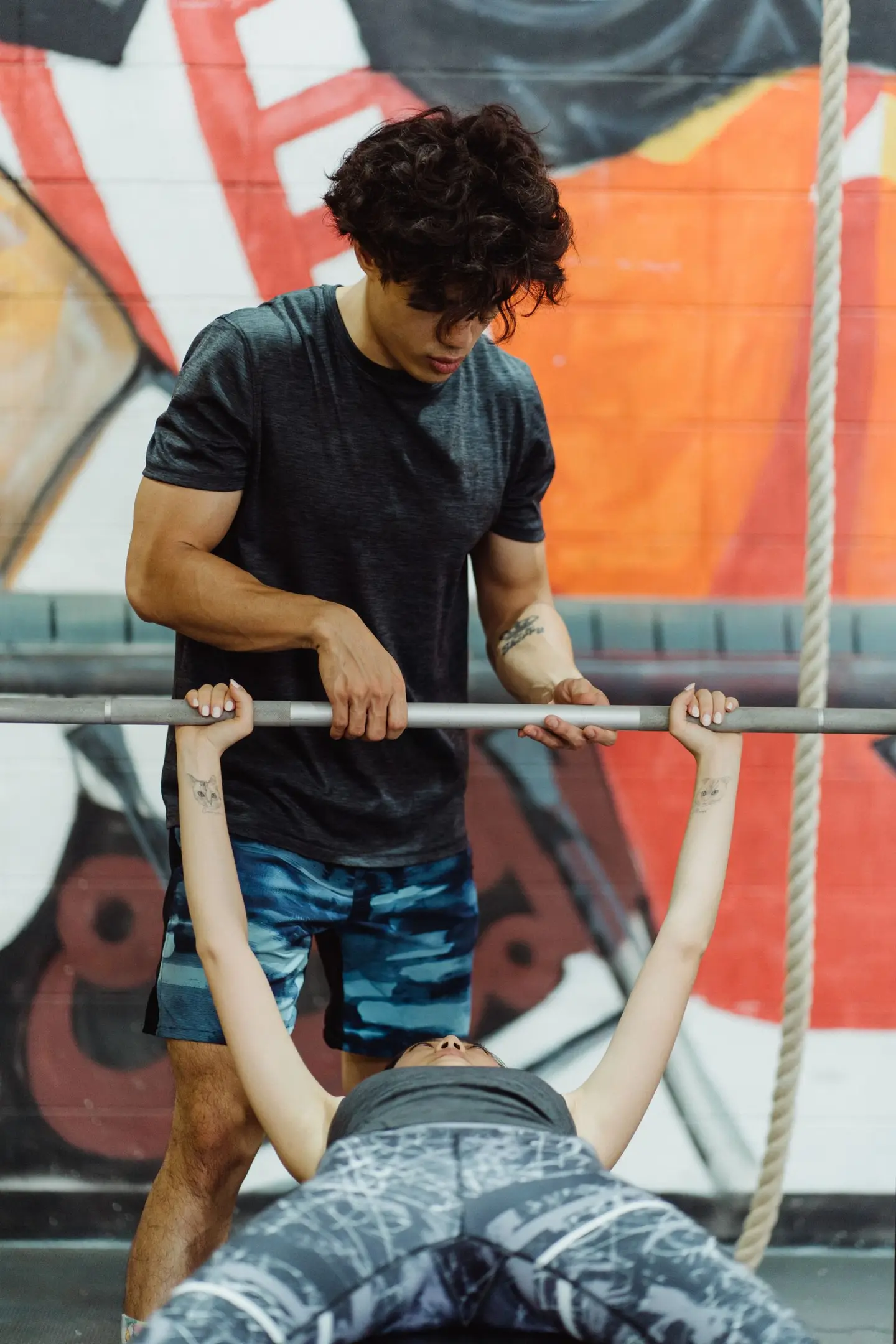 Man Assisting a Weightlifting Woman