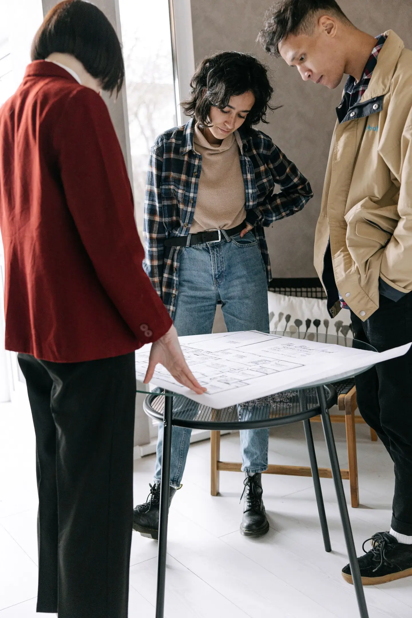 A Couple and an Architect Looking at a House Plan