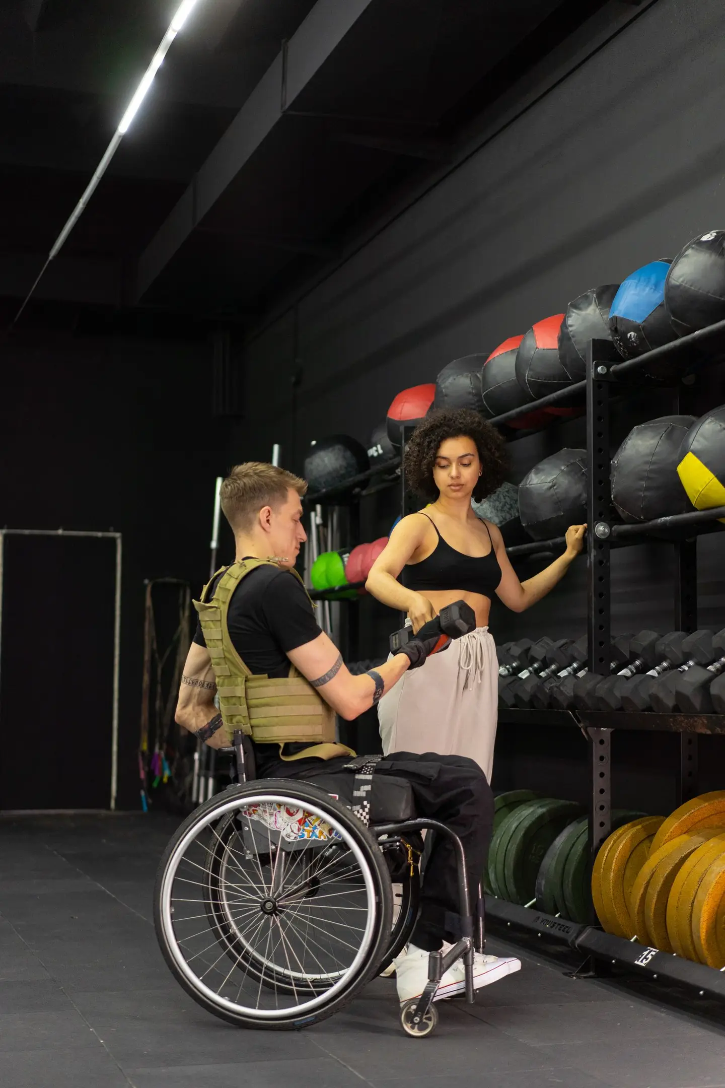 A Personal Trainer Handing a Dumbbell to her Client