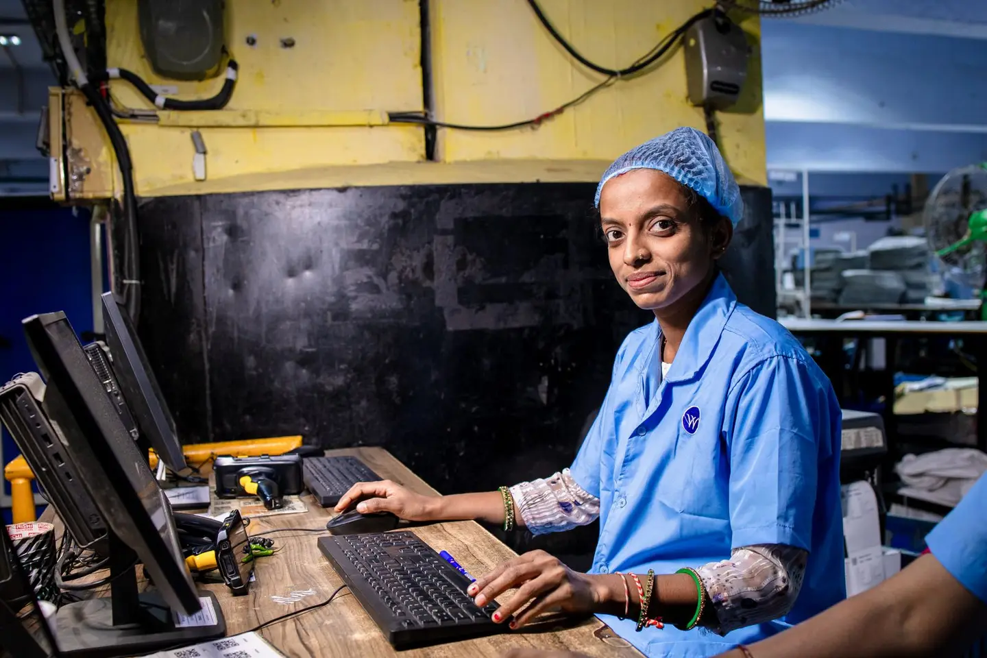 A factory worker using a computer at her workstation