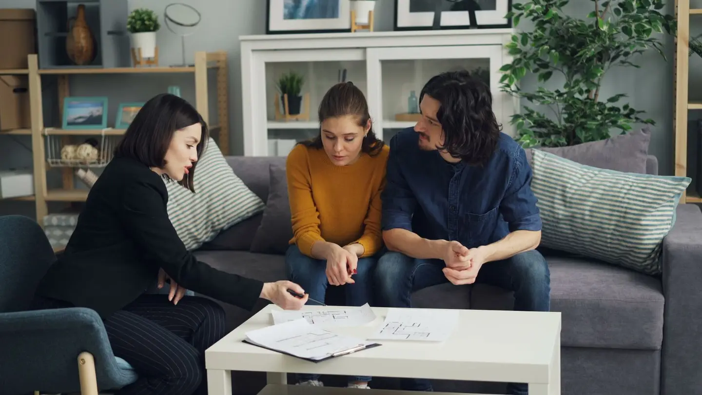 Couple and Real Estate Agent Sitting in House