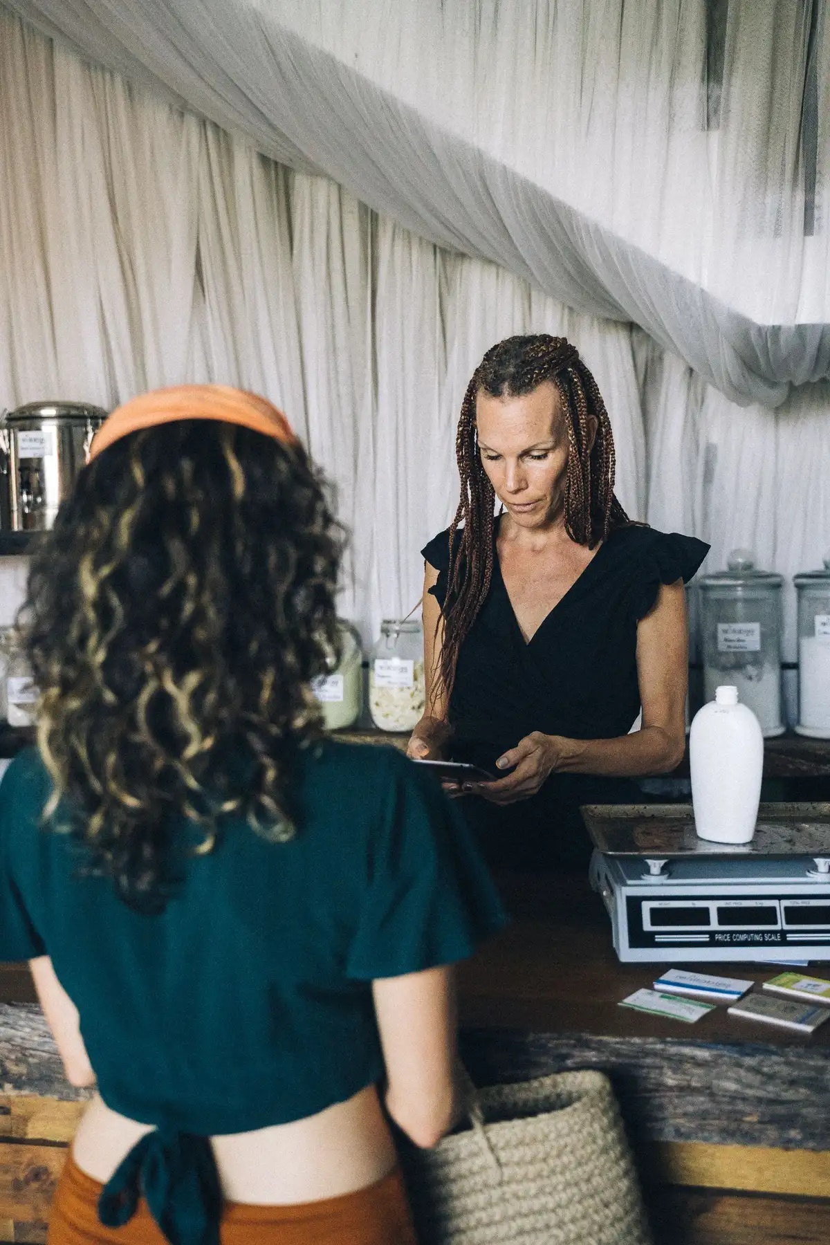 A Woman Standing Behind a Counter Across a Person